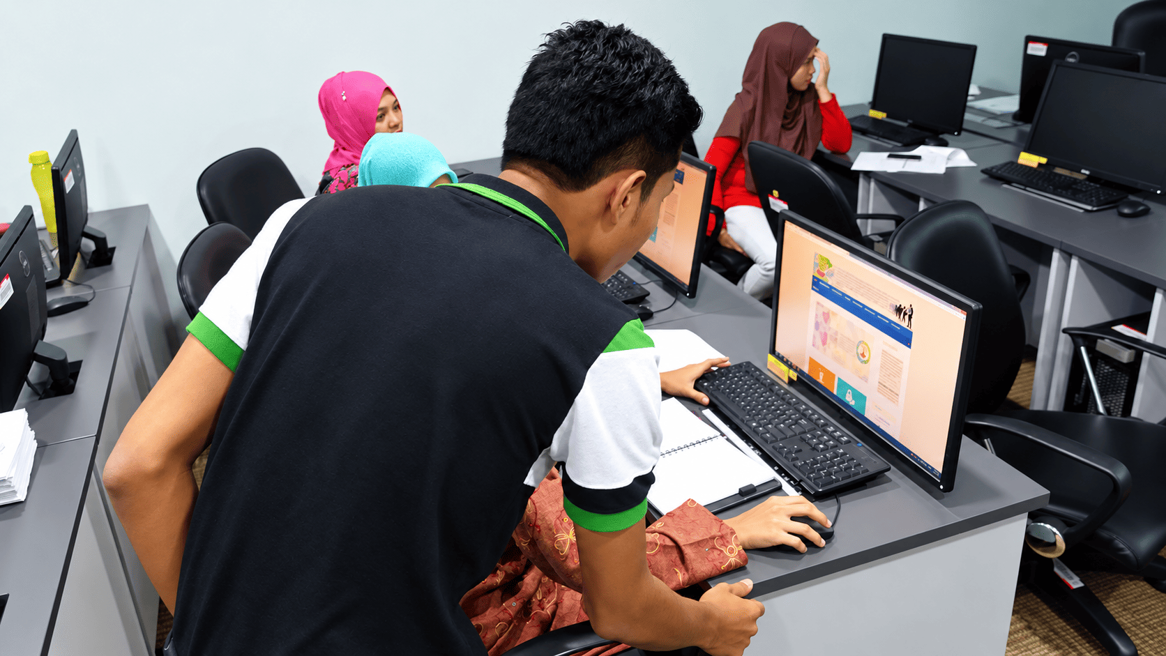 Trainer helping a participant use a web application at a computer workstation